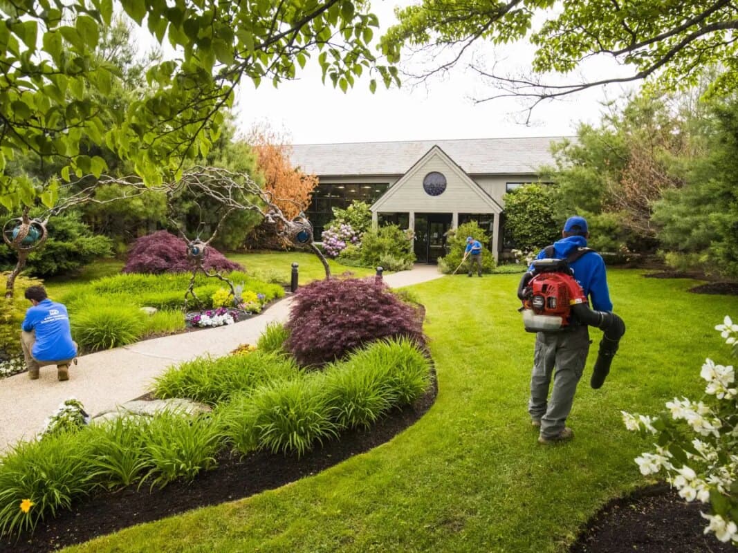 Landscaping crew maintaining a manicured garden and lawn on a property in New Castle County